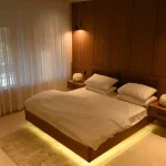 The Sultan Hotels luxury hotel room with warm LED lighting, wooden wall panels and white bedding in Islamabad